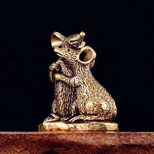 Vintage brass mouse figurine with detailed craftsmanship displayed on a dark background