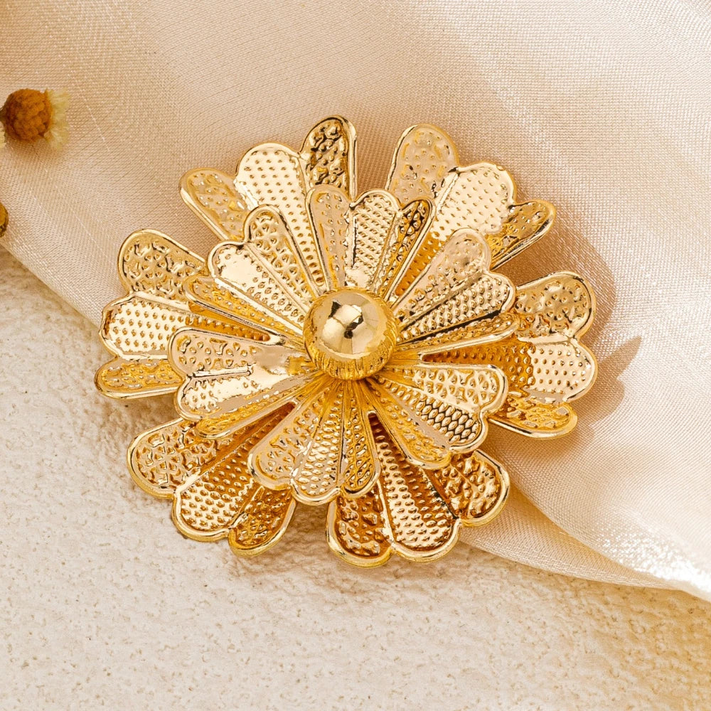 Gold flower-shaped decorative item on a beige fabric background