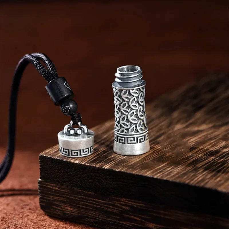 Silver decorative bottle with intricate designs on a wooden surface
