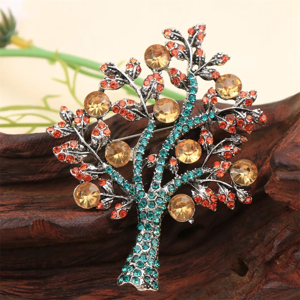 Elegant tree design brooch with multicolor gemstones on wooden surface