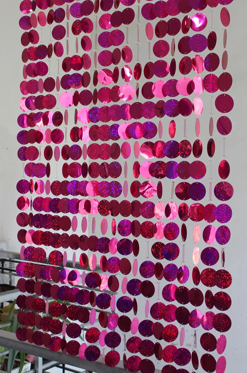 Pink and purple circular sequin curtain against a white background