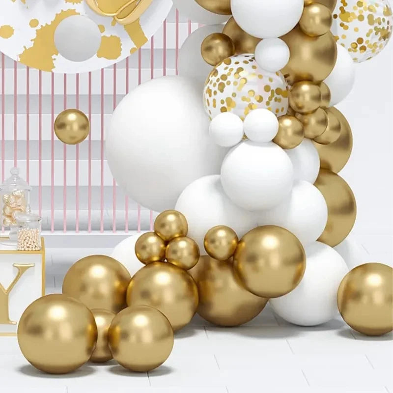 Gold and white balloon garland decoration set with large matte white balloons, shiny metallic gold balloons, and a round white balloon printed with gold confetti, arranged in a party decor setup.