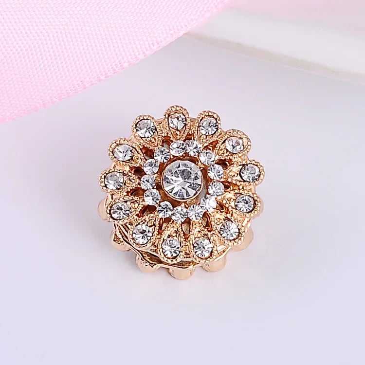 Luxury gold tone crystal flower hijab brooch pin on a light pink background