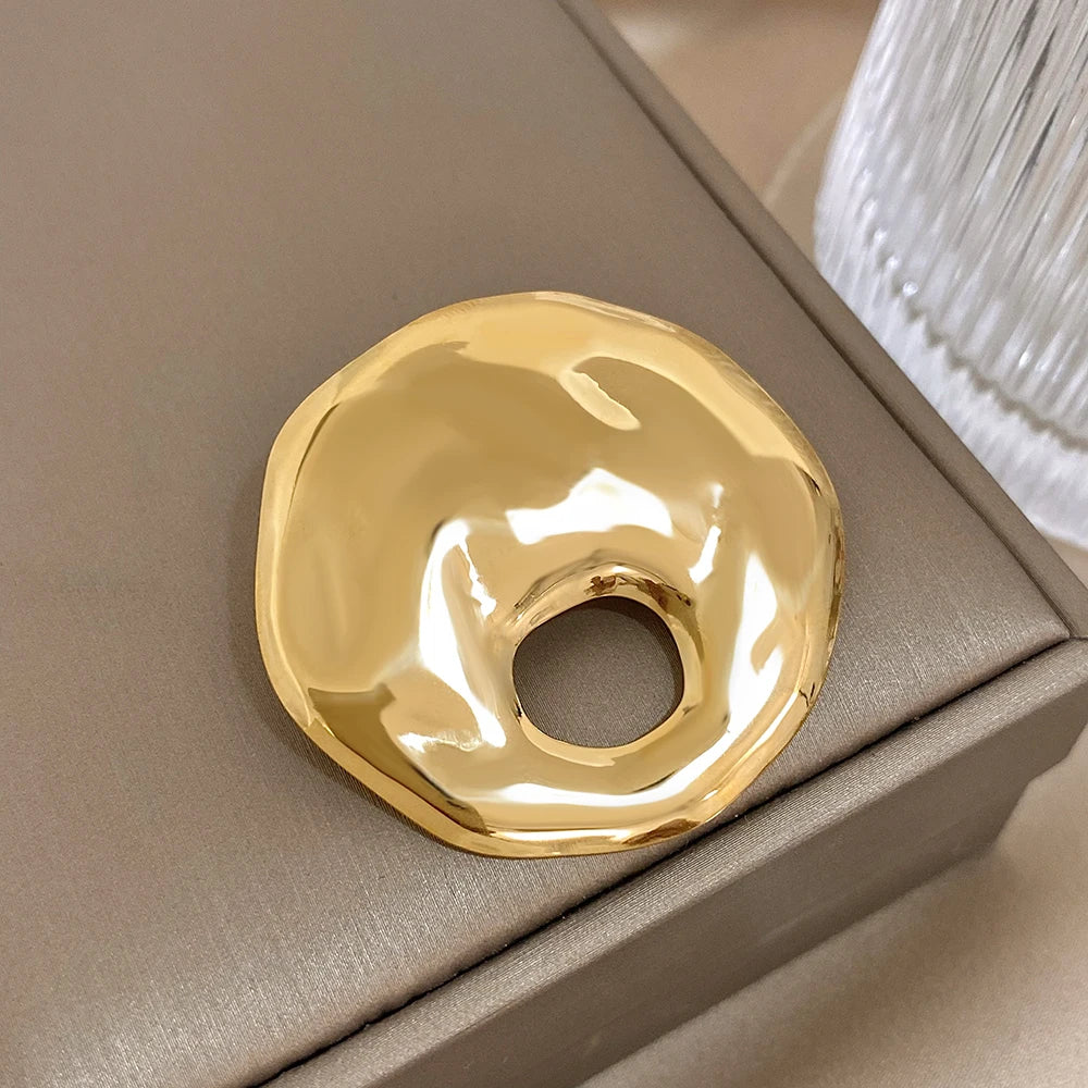 Gold decorative brooch on a beige surface